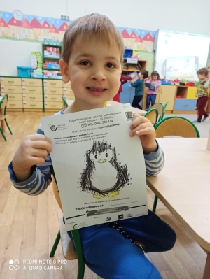 Chłopiec pokazuje zrobione zadanie - pingwinek.