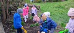 Dzieci przygotowują ziemię do sadzenia.