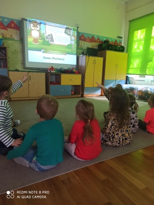 Dzieci oglądają prezentację o lesie, poznają wiadomości nt. zwierząt leśnych, tj. sowa.